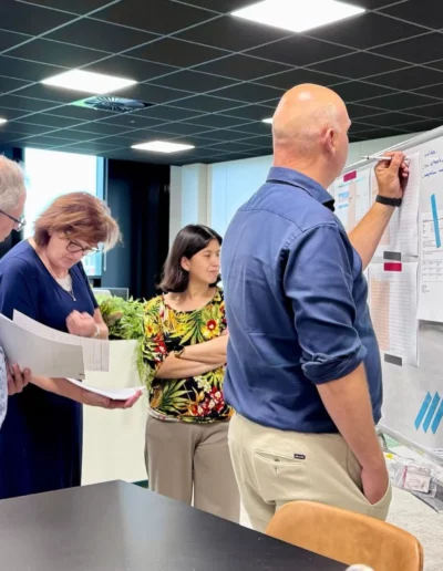Quatre employ&eacute;s de l'&eacute;quipe hollandaise travaillent autour d'un tableau blanc.
